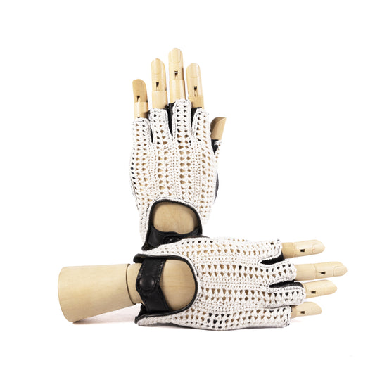 White crochet and black leather driving gloves displayed on a wooden mannequin hand, showcasing elegant Italian craftsmanship.