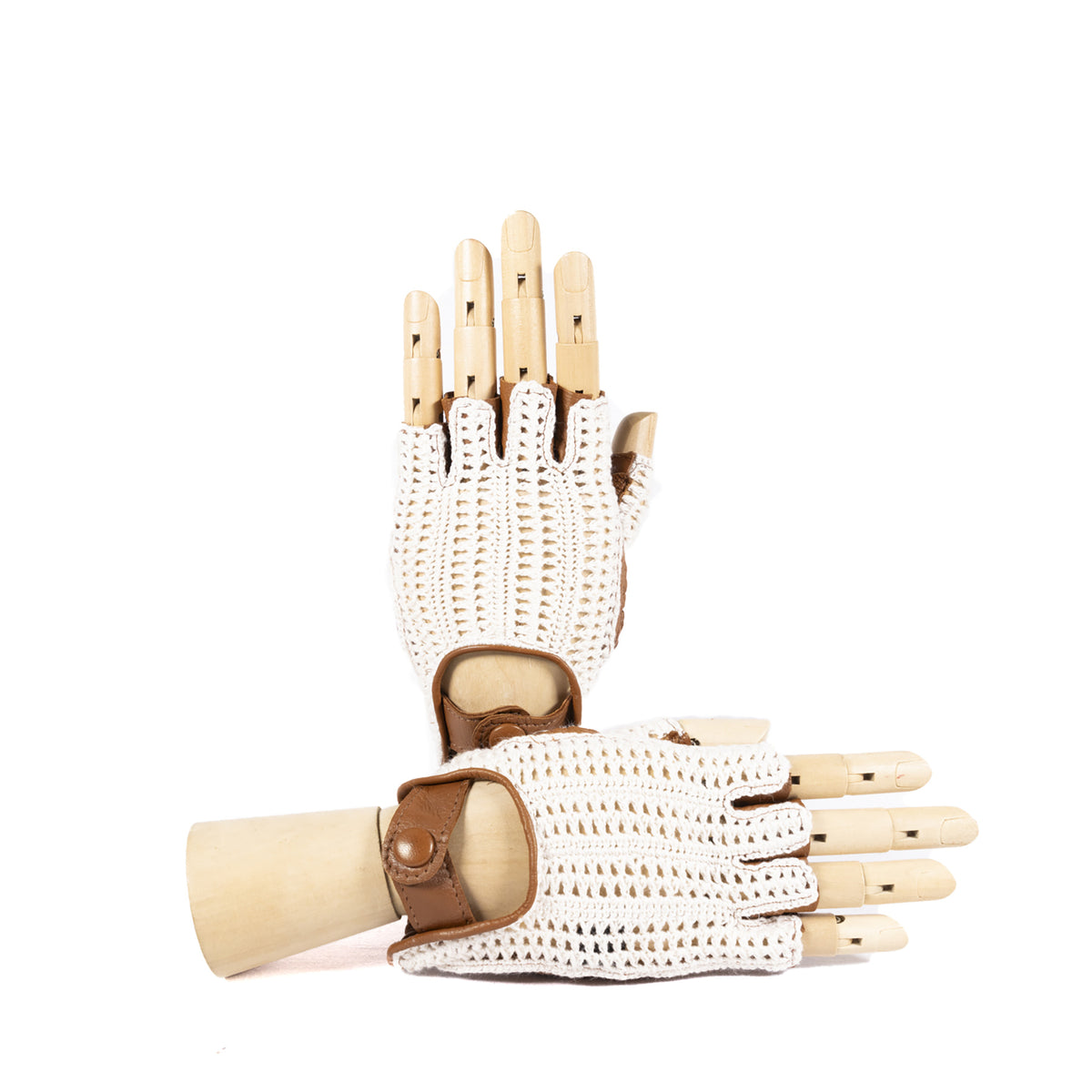 White crochet driving gloves with brown leather accents, elegantly displayed on a wooden hand model.