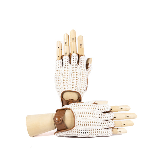 White crochet driving gloves with brown leather accents, elegantly displayed on a wooden hand model.