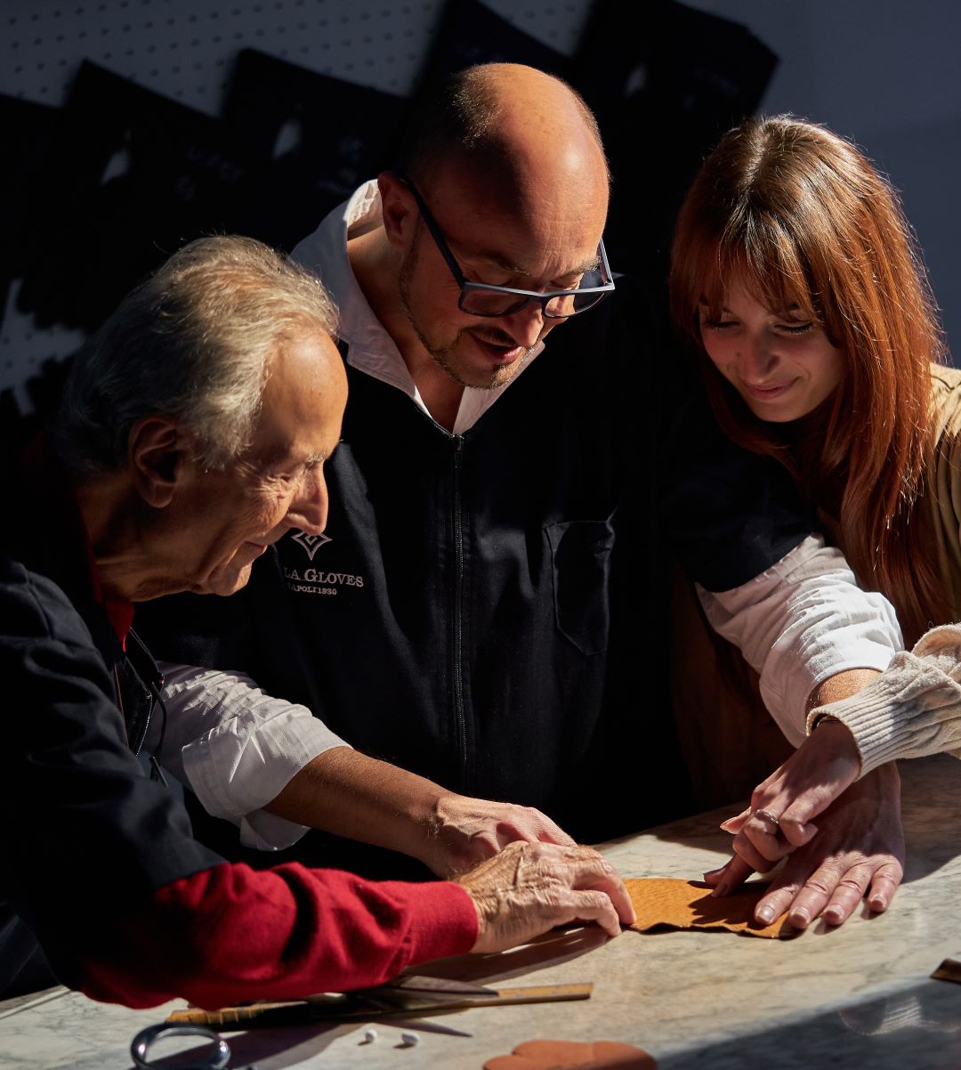 Artisans collaborating on leather pieces, showcasing traditional techniques in the creation of luxury Gala Gloves.