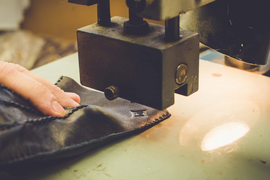 The creation of a pair of premium black leather gloves with elegant stitching detail